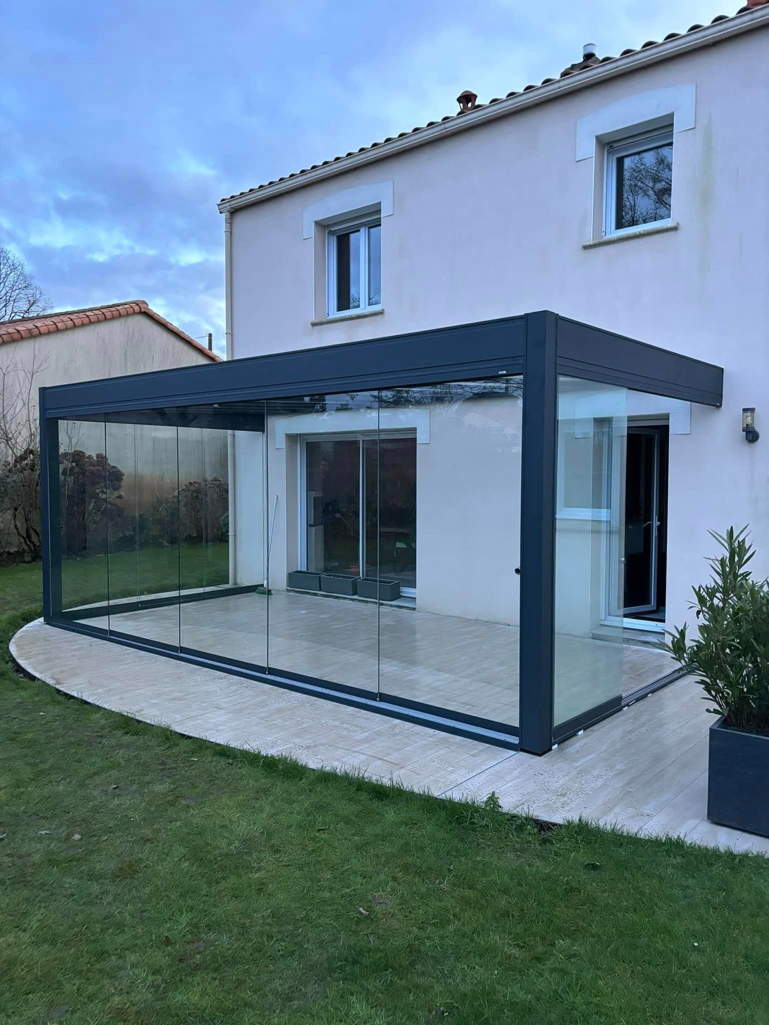 Véranda aluminium anthracite à rideau de verre, réalisée par AF Menuiseries